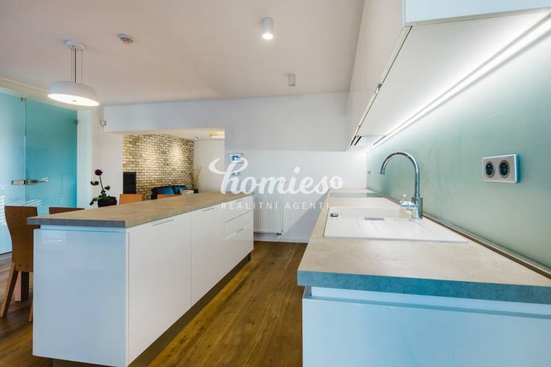 PREDAJ  kompletne prerobený 3 izbový rodinný dom, Nitra - centrum - Kuchyňa s ostrovčekom, tehlovou stenou a podlahou s dreveným dekorom v rodinnom dome.