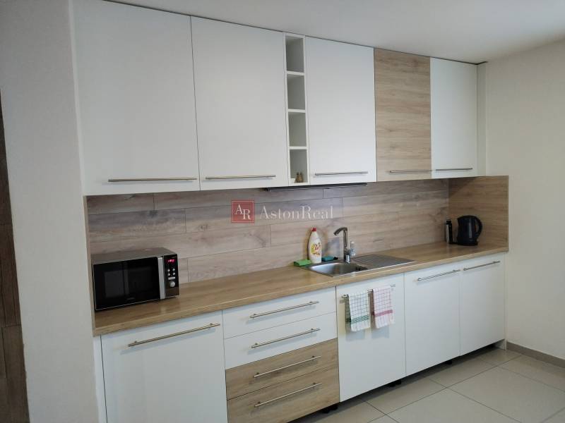 NOVOSTAVBA: 6-izbová CHATA, VL pozemok 484 m2 v Martine  - Kuchyňa na chate s bielymi skrinkami a podlahou s dreveným dekorom.