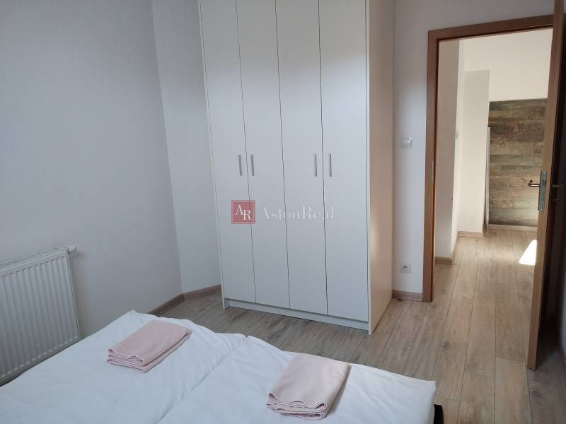 NOVOSTAVBA: 6-izbová CHATA, VL pozemok 484 m2 v Martine  - Spálňa v chate s bielou šatníkovou skriňou a podlahou s dreveným dekorom.