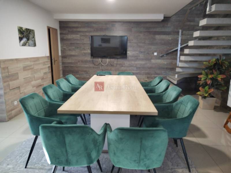 NOVOSTAVBA: 6-izbová CHATA, VL pozemok 484 m2 v Martine  - Jedáleň v chate s dreveným dekorom, schodiskom a zelenými stoličkami okolo stola.