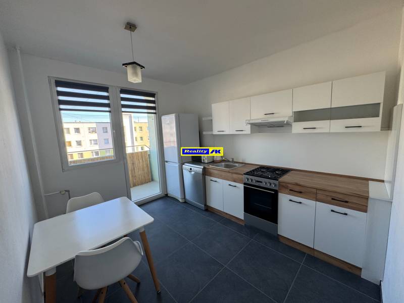 3 izbový zrekonštruovaný byt na prenájom - Martin - Kuchyňa v 3-izbovom byte s bielym nábytkom a jedálenským stolom.