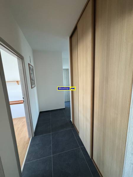 3 izbový zrekonštruovaný byt na prenájom - Martin - Chodba v 3-izbovom byte s tmavou dlažbou a vstavanou skriňou.