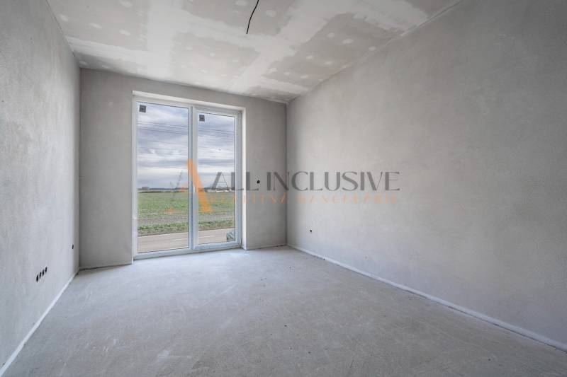 ALL INCLUSIVE I 3 IZBOVÉ BYTY S TERASOU, SO ZÁHRADOU + 2 PARK. MIESTA - Priestranná miestnosť s oknom v 3-izbovom byte so surovou podlahou.