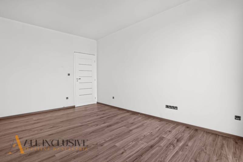 ALL INCLUSIVE I 3 IZBOVÉ BYTY S TERASOU, SO ZÁHRADOU + 2 PARK. MIESTA - Izba v 3-izbovom byte s bielymi stenami a podlahou s dreveným dekorom.