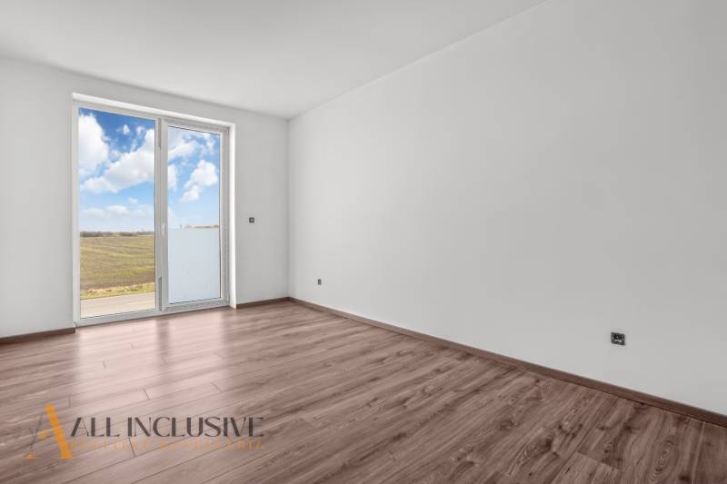 ALL INCLUSIVE I 3 IZBOVÉ BYTY S TERASOU, SO ZÁHRADOU + 2 PARK. MIESTA - Svetlá izba s podlahou s dreveným dekorom a veľkým oknom v 3-izbovom byte.