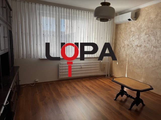 Prenájom 3izb. zariadeného bytu na Jazdeckej ul., Nové Zámky - Izba s podlahou s dreveným dekorom a stolíkom v 3-izbovom byte.