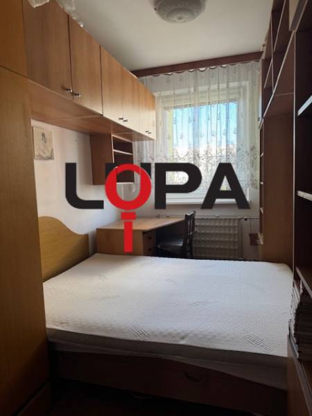 Prenájom 3izb. zariadeného bytu na Jazdeckej ul., Nové Zámky - Spálňa v 3-izbovom byte s posteľou, skriňami a oknom s čipkovanými záclonami.