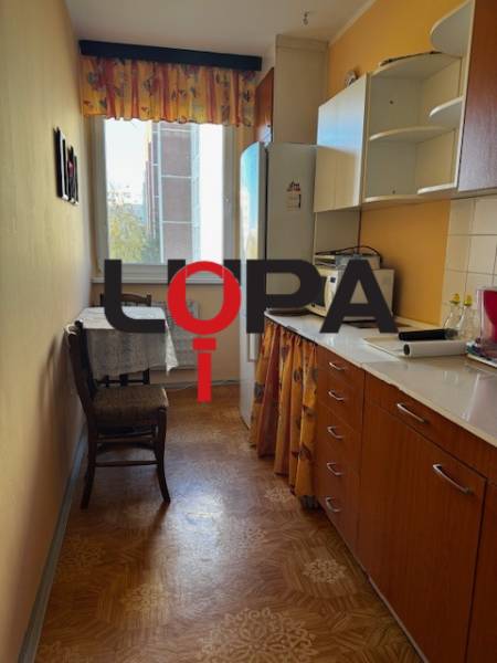 Prenájom 3izb. zariadeného bytu na Jazdeckej ul., Nové Zámky - Kuchyňa v 3-izbovom byte s podlahou s dreveným dekorom a nábytkom v teplých farbách.