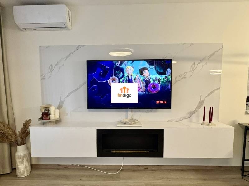 PRENÁJOM - 3-izbový veľkometrážny byt v RED OAK, Lužianky -REZERVOVANÉ - Obývacia izba v 3-izbovom byte s televízorom, policami a podlahou s dreveným dekorom.