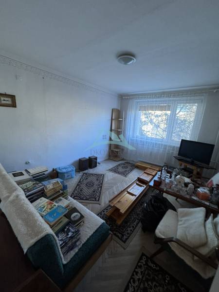 Šahy – 3i Byt v Centre Mesta s Balkónom  - Obývacia izba v 3-izbovom byte s podlahou s dreveným dekorom a nábytkom.