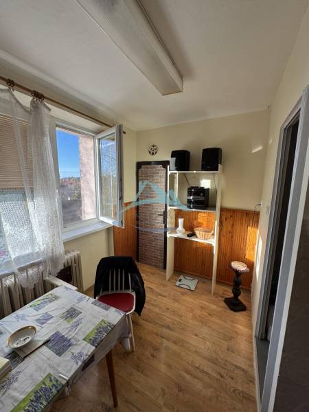 Šahy – 3i Byt v Centre Mesta s Balkónom  - Jedáleň v 3-izbovom byte s podlahou s dreveným dekorom a otvoreným oknom.