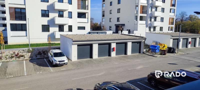 | 2-izbový byt, ul. Predmerského VINOHRADY | Trenčín  - Pohľad na Predmerského ulicu v Trenčíne s bytovým domom a parkovaním.