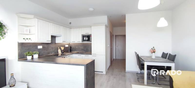 | 2-izbový byt, ul. Predmerského VINOHRADY | Trenčín  - Kuchyňa a jedálenský kút v 2-izbovom byte s podlahou s dreveným dekorom.