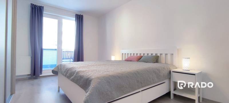 | 2-izbový byt, ul. Predmerského VINOHRADY | Trenčín  - Spálňa v 2-izbovom byte so svetlým nábytkom a podlahou s dreveným dekorom.