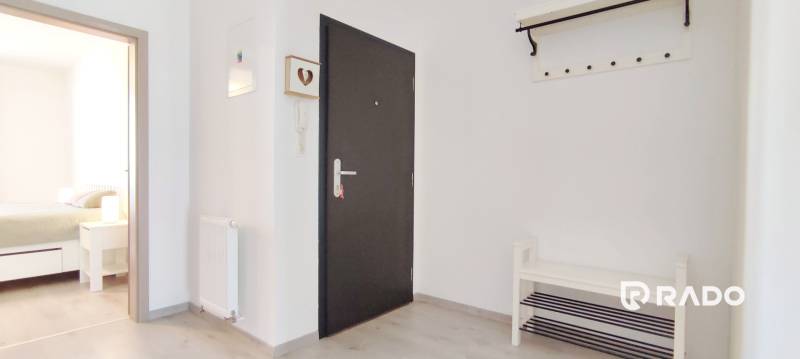 | 2-izbový byt, ul. Predmerského VINOHRADY | Trenčín  - Vstupná chodba so svetlými stenami a podlahou s dreveným dekorom, vedie do spálne.