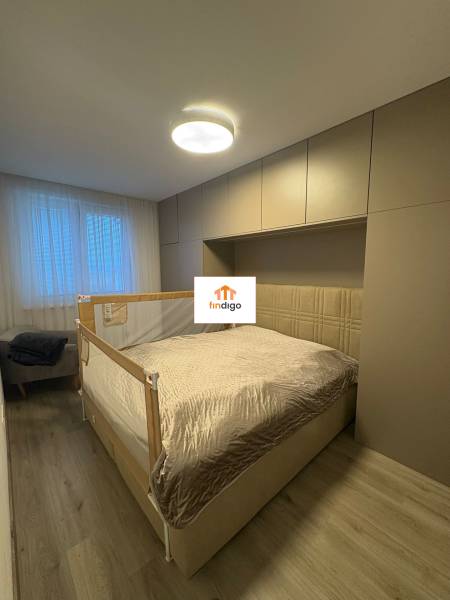 PREDAJ - 3-izbový veľkometrážny byt v RED OAK, Lužianky - REZERVOVANÉ - Spálňa v 3-izbovom byte s posteľou, svetlými skriňami a podlahou s dreveným dekorom.