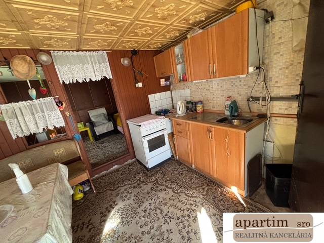 Apartim predá záhradu s možnosťou výstavby na Strednej ul v Ružinove - Kuchyňa s dreveným dekorom, pohovkou a kobercom v Záhradách.
