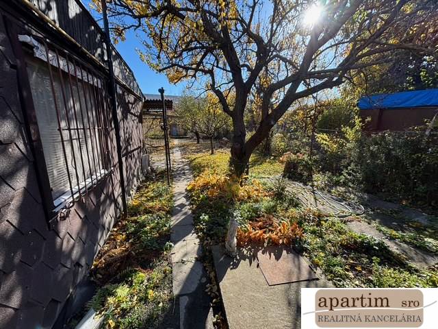 Apartim predá záhradu s možnosťou výstavby na Strednej ul v Ružinove - Záhrady na Strednej ulici v Bratislave – Ružinove s chodníkom a stromami.
