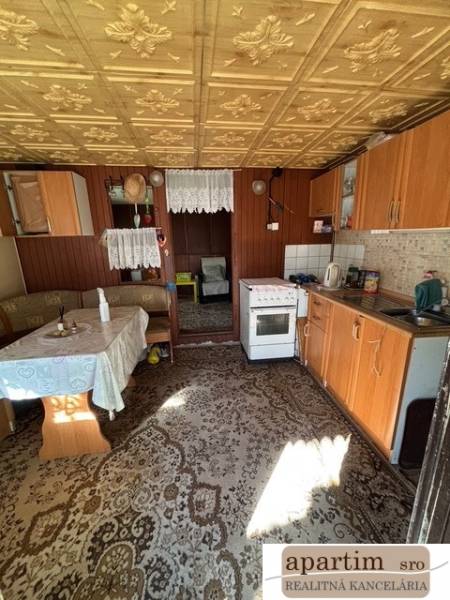 Apartim predá záhradu s možnosťou výstavby na Strednej ul v Ružinove - Kuchyňa so starším nábytkom, podlaha s dreveným dekorom, viditeľná jedálenská časť.