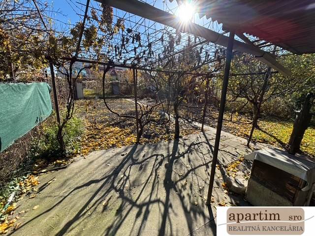 Apartim predá záhradu s možnosťou výstavby na Strednej ul v Ružinove - Jesenná záhrada v Bratislave - Ružinov na Strednej ulici s pergolou a opadanými listami.