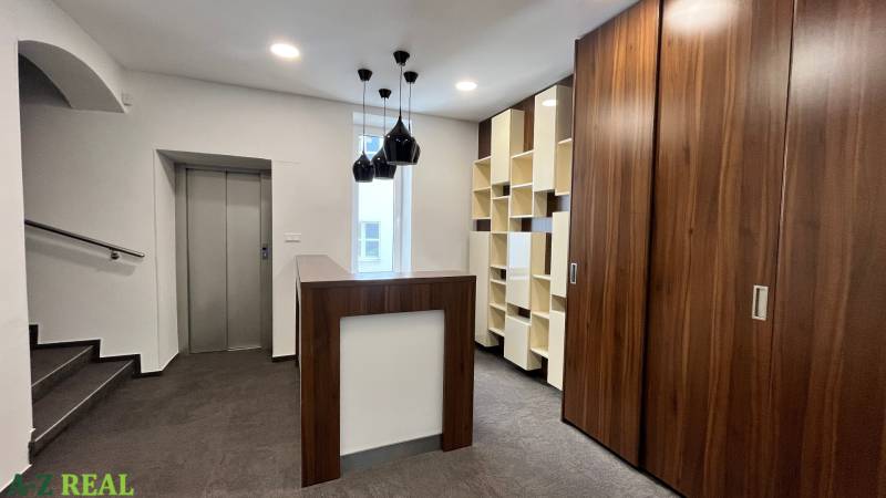 Prenájom nadštandardne zariadených kancelárií  v centre, 151 m2 - Kancelárie s drevenými prvkami, výťahom, moderným osvetlením a tmavou podlahou s dreveným dekorom.