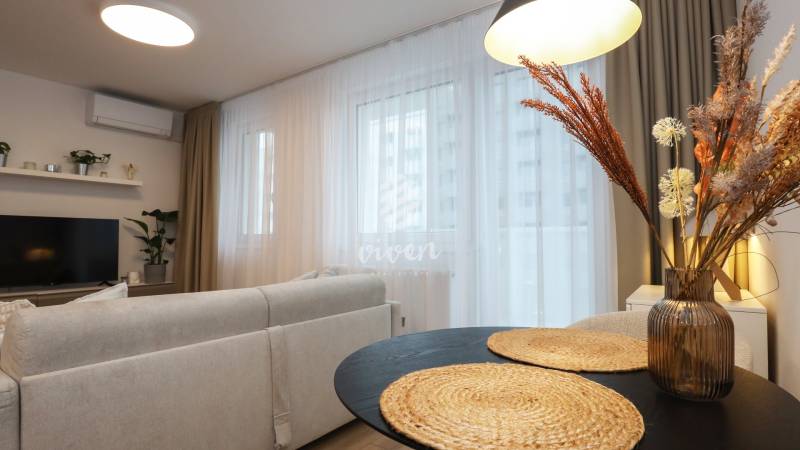 PRENÁJOM - 1 izbový byt v projekte Ovocné sady - Obývacia izba v 1-izbovom byte s pohodlným sedením a dekoratívnymi prvkami.