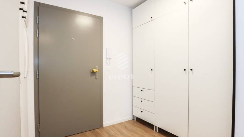 PRENÁJOM - 1 izbový byt v projekte Ovocné sady - Vstupná hala v 1-izbovom byte s bielou skriňou a podlahou s dreveným dekorom.