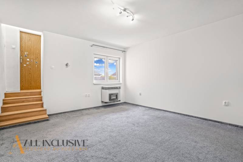 NA PREDAJ 4+1-IZBOVÝ ROD. DOM, VEĽKÉ KOSIHY - Biela izba s kobercovou podlahou, drevenými schodmi a stenou s oknom v rodinnom dome.