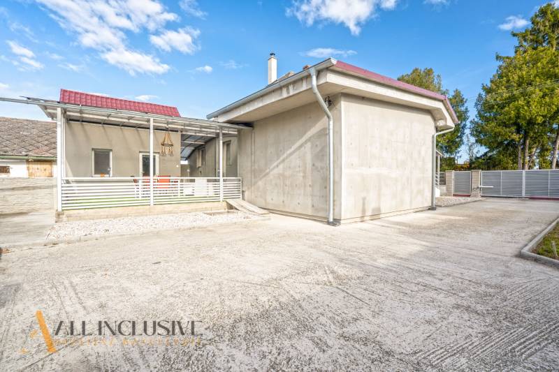 NA PREDAJ 4+1-IZBOVÝ ROD. DOM, VEĽKÉ KOSIHY - Rodinný dom vo Veľkých Kosihách s terasou a širokým príjazdom, obklopený zeleňou.