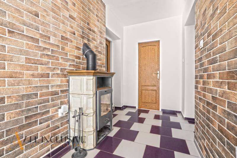 NA PREDAJ 4+1-IZBOVÝ ROD. DOM, VEĽKÉ KOSIHY - Interiér rodinného domu s kachľovou pecou a tehlovými stenami.