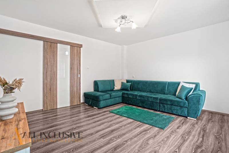 NA PREDAJ 4+1-IZBOVÝ ROD. DOM, VEĽKÉ KOSIHY - Obývacia izba v rodinnom dome s pohovkou a podlahou s dreveným dekorom.