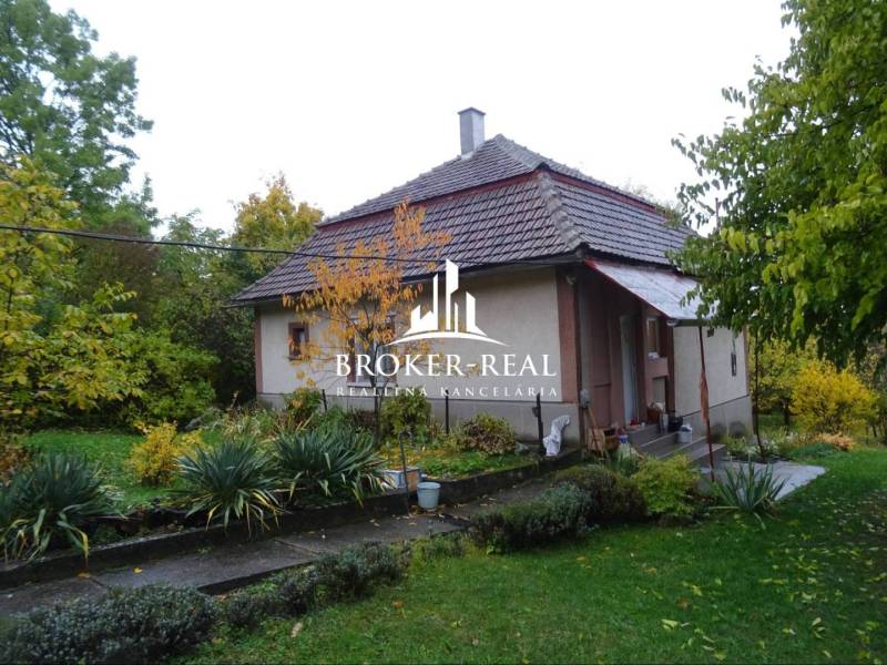 Rodinný dom, chalupa 2 Izbový - Fony - Rodinný dom vo Fony s veľkou záhradou, obklopený zeleňou a stromami.