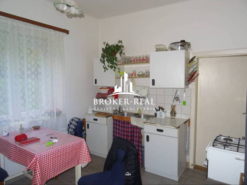 Rodinný dom, chalupa 2 Izbový - Fony - Kuchyňa v rodinnom dome s klasickým zariadením, záclony, biely kuchynský nábytok.