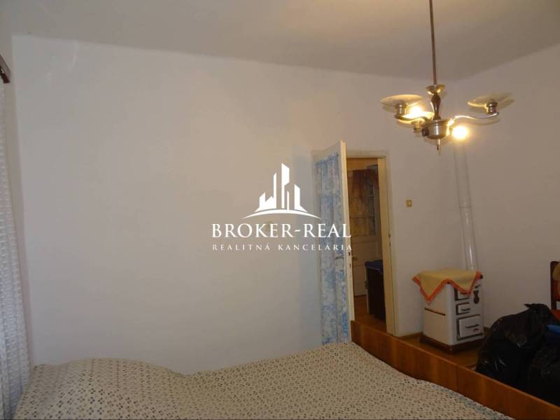 Rodinný dom, chalupa 2 Izbový - Fony - Spálňa v rodinnom dome s jednoduchým zariadením a retro kúrením.