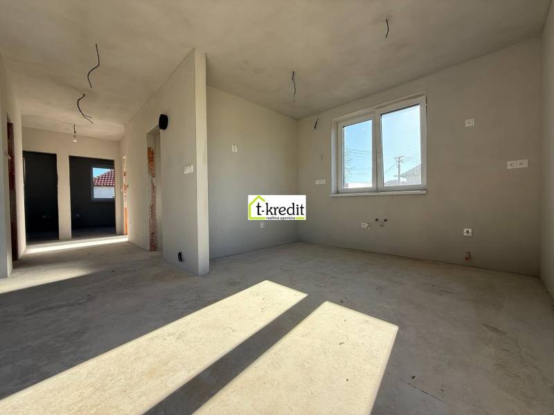 PREDAJ - NOVOSTAVBA - TESÁRSKE MLYŇANY - Interiér rodinného domu s nedokončenými stenami a oknom, podlaha s dreveným dekorom.