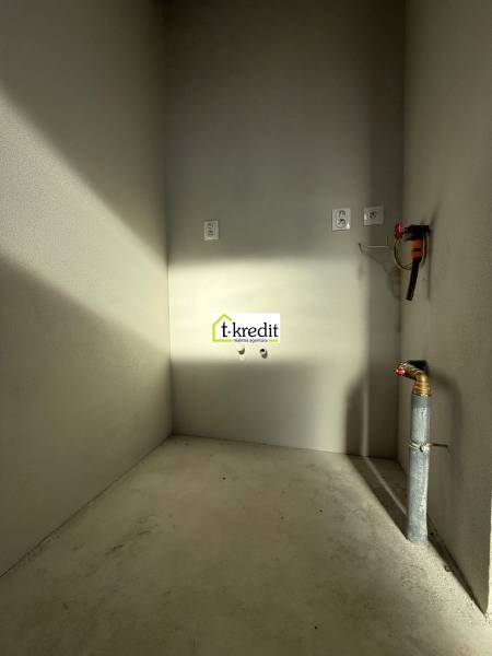 PREDAJ - NOVOSTAVBA - TESÁRSKE MLYŇANY - Prázdna miestnosť s betónovou podlahou a inštaláciami v rodinnom dome.