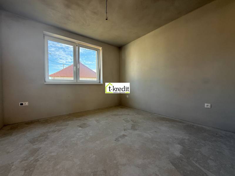 PREDAJ - NOVOSTAVBA - TESÁRSKE MLYŇANY - Miestnosť v rodinnom dome, steny bez dekorácií, vidno strechu susednej budovy.