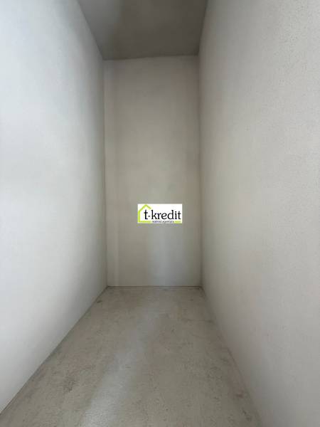 PREDAJ - NOVOSTAVBA - TESÁRSKE MLYŇANY - Úzky, prázdny interiér rodinného domu s betónovou podlahou a bielymi stenami.