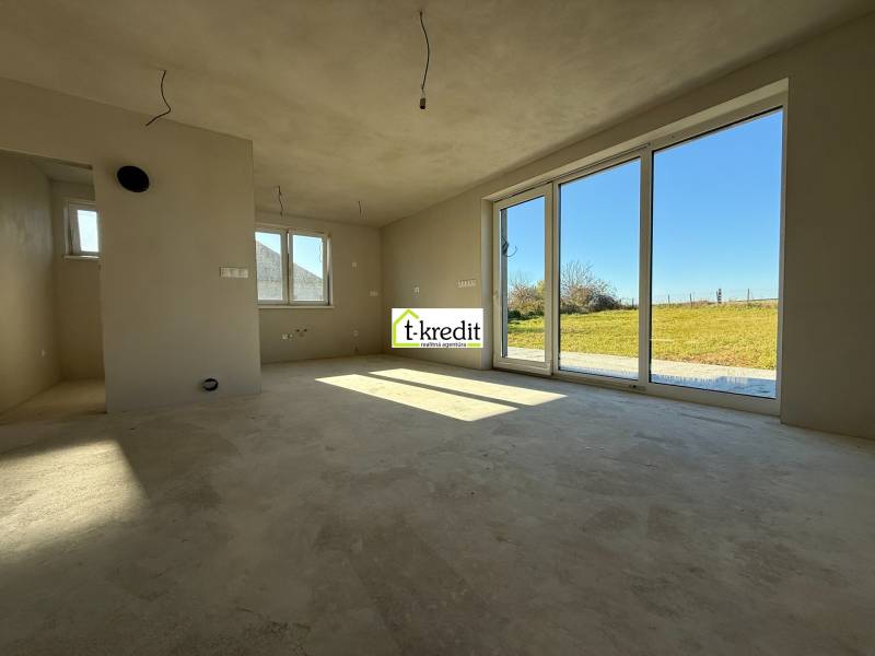 PREDAJ - NOVOSTAVBA - TESÁRSKE MLYŇANY - Priestranný interiér rodinného domu s veľkými oknami a výhľadom na záhradu.