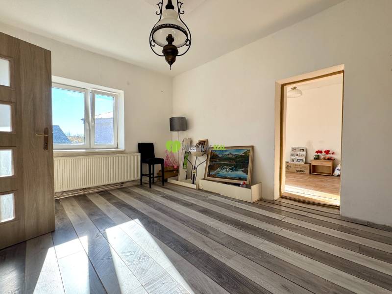 Na predaj 3i rodinný dom – Družstevná pri Hornáde, Košice - okolie - Izba v rodinnom dome s bielymi stenami, podlahou s dreveným dekorom a veľkým oknom.