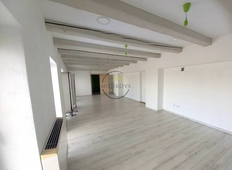 Prenajmeme kancelársky priestor, 40 m2, Levická ul., Vráble - Prázdna kancelária s bielymi stenami a podlahou s dreveným dekorom.