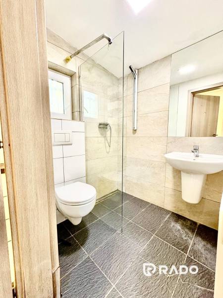 RADO I NA PRENAJOM I ZARIADENY 1-IZBOVY DOM I BA-PRIEVOZ - Kúpeľňa v rodinnom dome s preskleným sprchovým kútom a tmavou dlažbou.