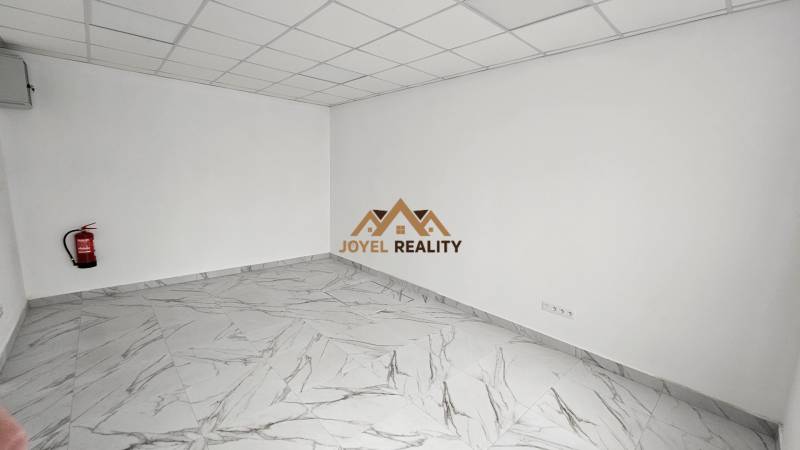 Obchodný priestor na prenájom v meste Galanta - Obchodné priestory s mramorovou podlahou a hasiacim prístrojom pri stene.