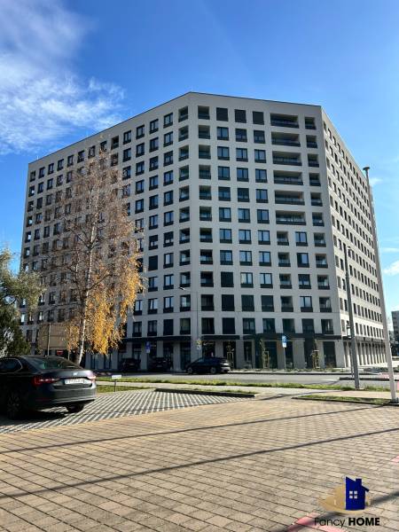 PRENÁJOM garáž Poprad, ul. Karpatská - Bytový dom na Karpatskej ulici v Poprade, okolité parkovisko a stromy.