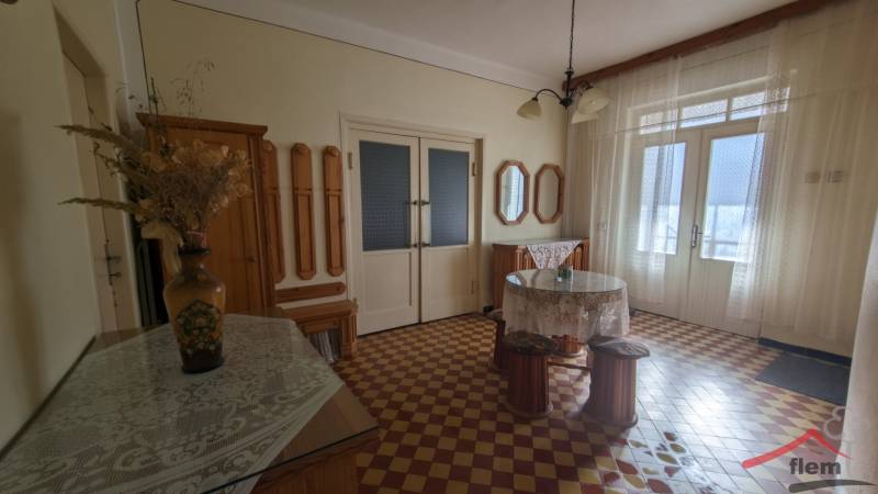 5-izbový rodinný dom na predaj v Hornom Ohaji, okr. NR, pozemok 1251m2 - Interiér rodinného domu s farebnou dlažbou, kvetinovou vázou a záclonami.