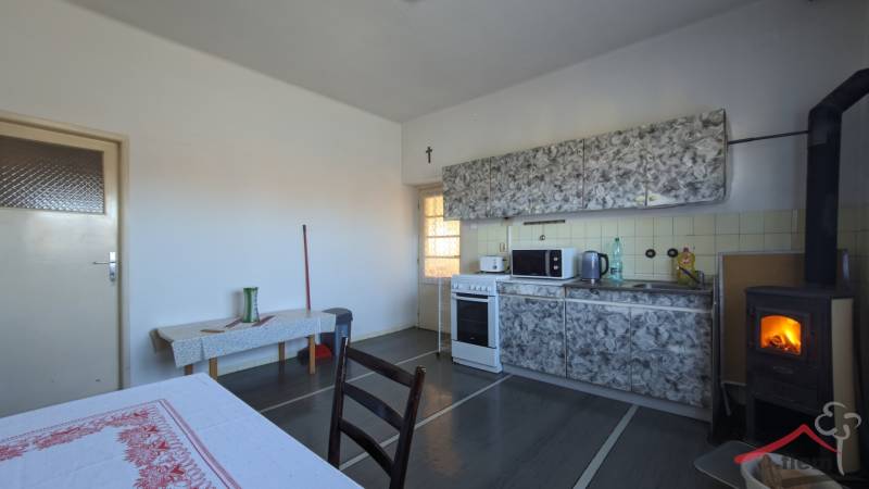 5-izbový rodinný dom na predaj v Hornom Ohaji, okr. NR, pozemok 1251m2 - Kuchyňa v rodinnom dome s pieckou a kuchynskou linkou, podlaha s dreveným dekorom.