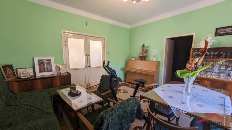 5-izbový rodinný dom na predaj v Hornom Ohaji, okr. NR, pozemok 1251m2 - Obývacia izba v rodinnom dome s nábytkom, cvičebným zariadením a zelenými stenami.