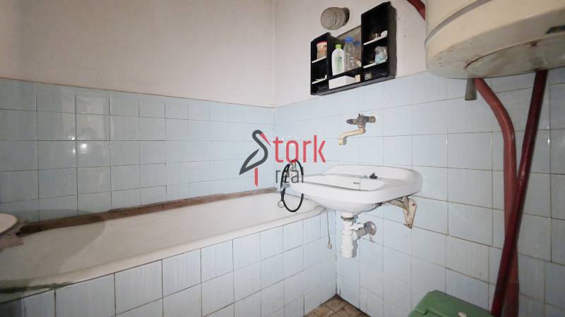 Menší rodinný dom len pár metrov od centra mesta Rajec - Kúpeľňa s vaňou, umývadlom a modrými obkladačkami v rodinnom dome.