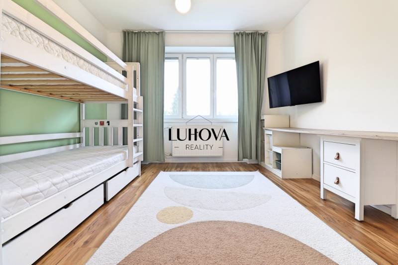 Na PRENÁJOM_ NÁDHERNÝ 3-izbový byt  - Izba v 3-izbovom byte s poschodovou posteľou, televízorom a podlahou s dreveným dekorom.