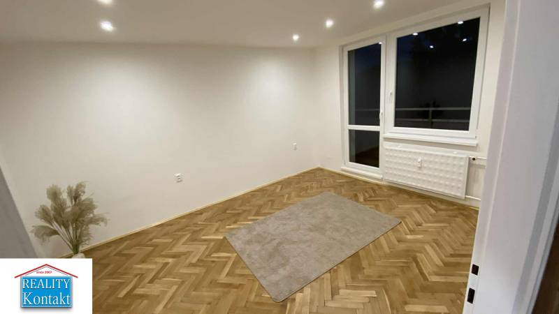 Na prenájom 1-izbový byt - Nové Zámky - Izba v 1-izbovom byte s podlahou s dreveným dekorom a veľkým oknom.